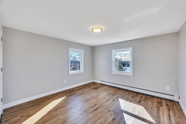 7 Howard Ave, Freeport, NY 11520 - empty room featuring a baseboard heating unit, plenty of natural light, baseboards, and wood finished floors