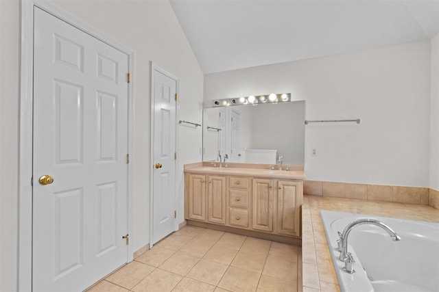 full bath with a sink, tile patterned floors, vaulted ceiling, double vanity, and a garden tub