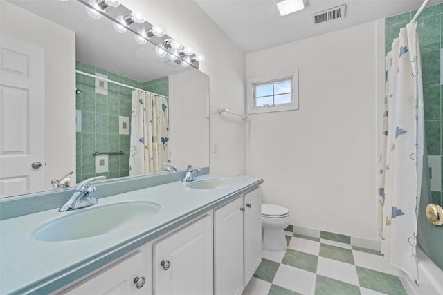 full bathroom with toilet, tile patterned floors, visible vents, and a sink