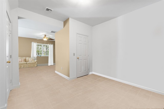 spare room featuring baseboards, a ceiling fan, and visible vents