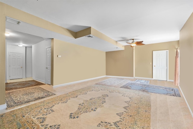 empty room featuring baseboards, a ceiling fan, and visible vents