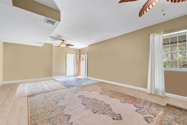 empty room featuring a healthy amount of sunlight, visible vents, ceiling fan, and light tile patterned flooring