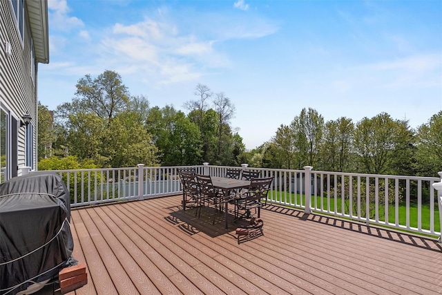 wooden terrace featuring area for grilling and outdoor dining area