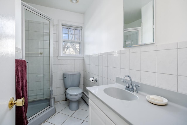 full bathroom featuring tile patterned flooring, toilet, tile walls, a baseboard heating unit, and a stall shower