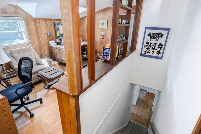 interior space featuring wooden walls, vaulted ceiling, and wood finished floors