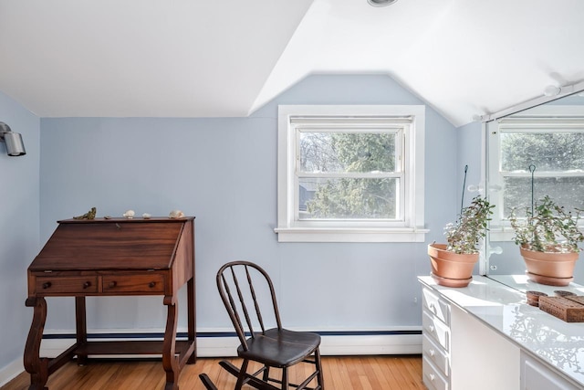 sitting room with light wood-style floors, lofted ceiling, and a healthy amount of sunlight