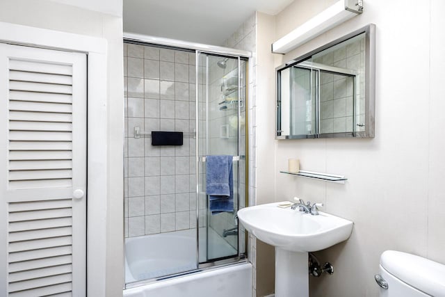 full bathroom featuring shower / bath combination with glass door and toilet