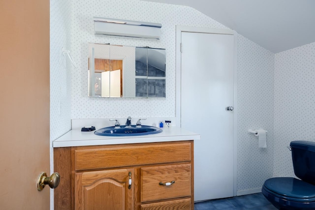bathroom featuring vanity, toilet, and wallpapered walls