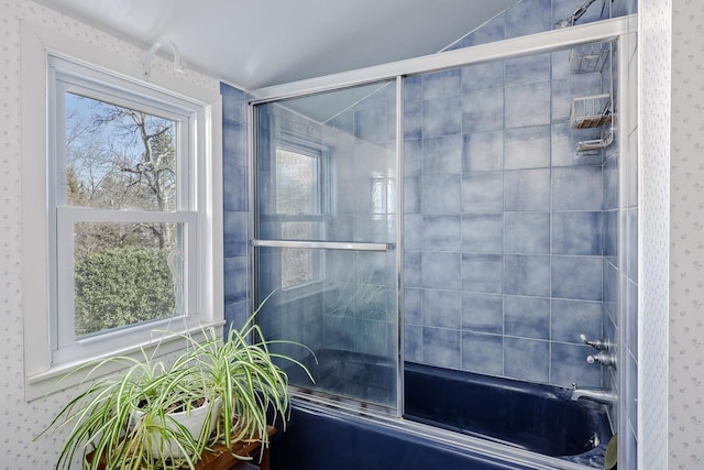 full bathroom featuring combined bath / shower with glass door, wallpapered walls, and a wealth of natural light