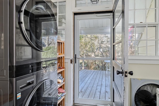 clothes washing area with stacked washer and clothes dryer and laundry area