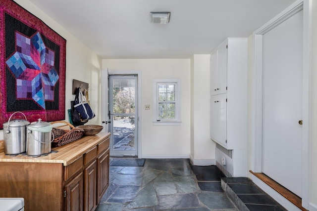 interior space with baseboards and stone finish floor