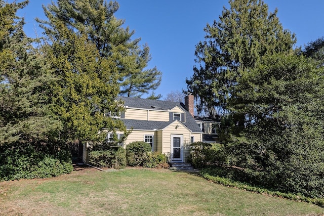 view of front of property featuring a chimney and a front yard