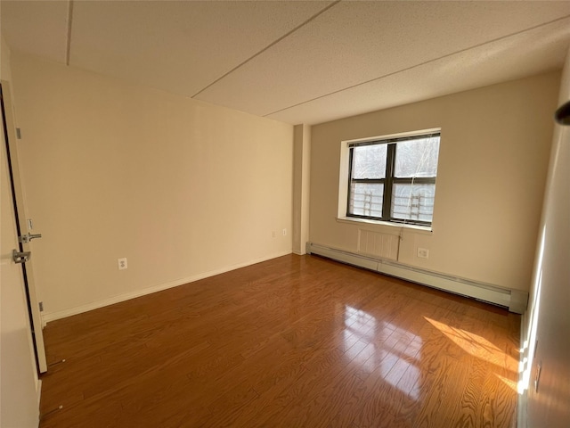 1259 Grant Ave Unit 8A, Bronx, NY 10456 - spare room with a baseboard heating unit, baseboards, and wood finished floors