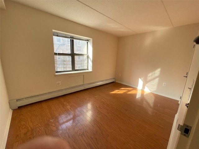 1259 Grant Ave Unit 8A, Bronx, NY 10456 - spare room featuring a baseboard heating unit, wood finished floors, and baseboards