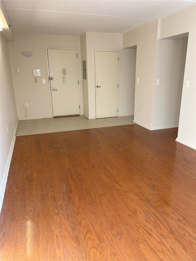 1259 Grant Ave Unit 8A, Bronx, NY 10456 - spare room featuring electric panel, baseboards, a textured ceiling, and wood finished floors