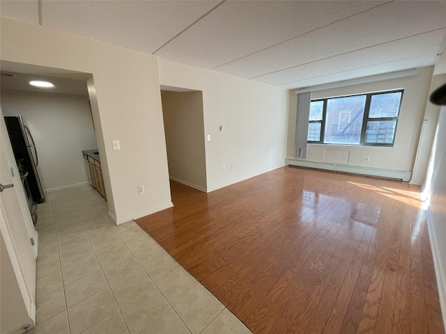 1259 Grant Ave Unit 8A, Bronx, NY 10456 - empty room featuring light wood-style flooring, baseboards, and a baseboard radiator