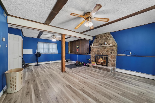 unfurnished living room featuring baseboards, beamed ceiling, a ceiling fan, and a textured ceiling