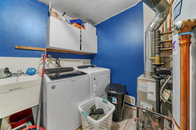 washroom featuring separate washer and dryer, a sink, cabinet space, and wood finished floors