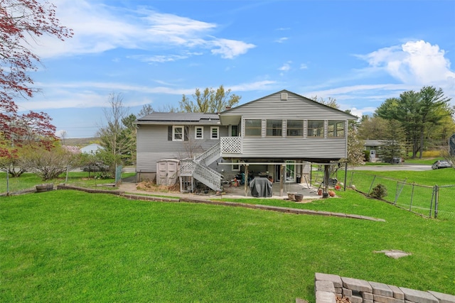 rear view of property featuring stairs, a sunroom, solar panels, a lawn, and a patio