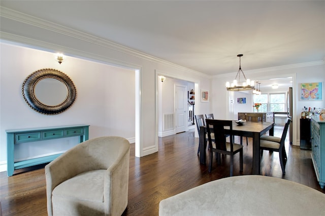 dining room with dark wood finished floors, baseboards, visible vents, a chandelier, and crown molding