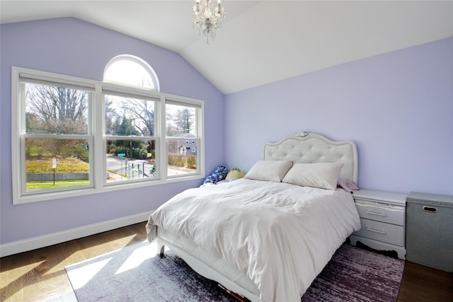 bedroom with lofted ceiling, baseboards, and dark wood-style flooring