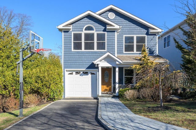 traditional-style home featuring an attached garage and aphalt driveway