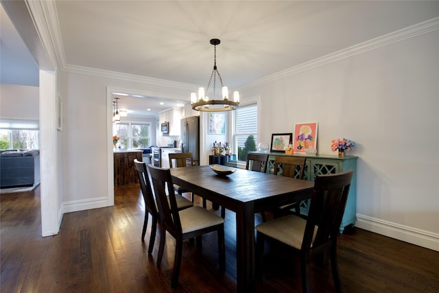 dining space with dark wood finished floors, an inviting chandelier, crown molding, and baseboards