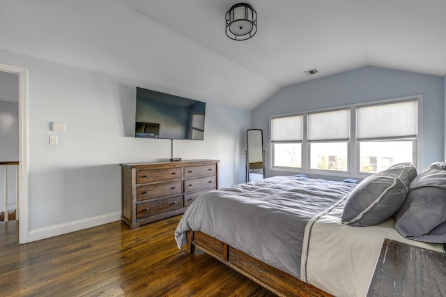 bedroom featuring lofted ceiling, baseboards, wood finished floors, and visible vents