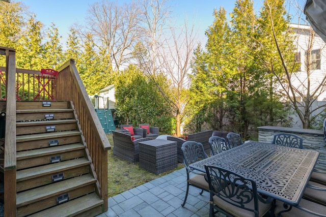 view of patio with outdoor dining area, stairs, and an outdoor hangout area