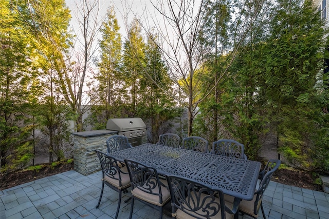 view of patio featuring exterior kitchen, outdoor dining area, and a grill