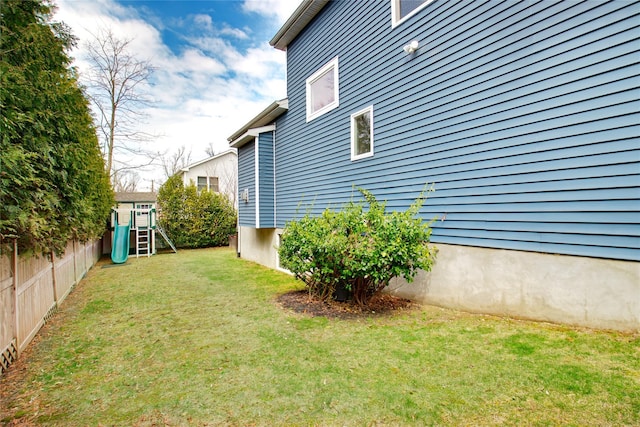 view of yard with fence and a playground
