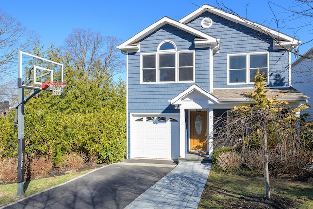 traditional-style house featuring an attached garage and aphalt driveway