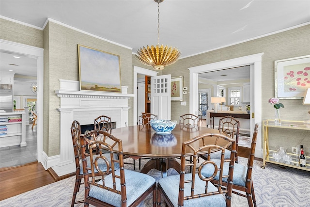 33 Fernwood Rd, Larchmont, NY 10538 - dining area with a chandelier, a fireplace, crown molding, wallpapered walls, and wood finished floors