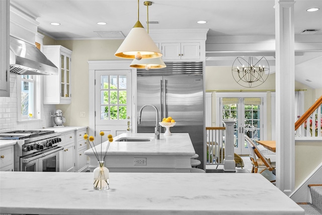 33 Fernwood Rd, Larchmont, NY 10538 - kitchen with white cabinetry, decorative backsplash, a sink, premium appliances, and wall chimney exhaust hood