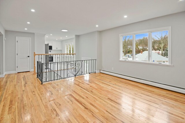 161 Cherry St, Northport, NY 11768 - empty room featuring baseboard heating, light wood finished floors, recessed lighting, and baseboards