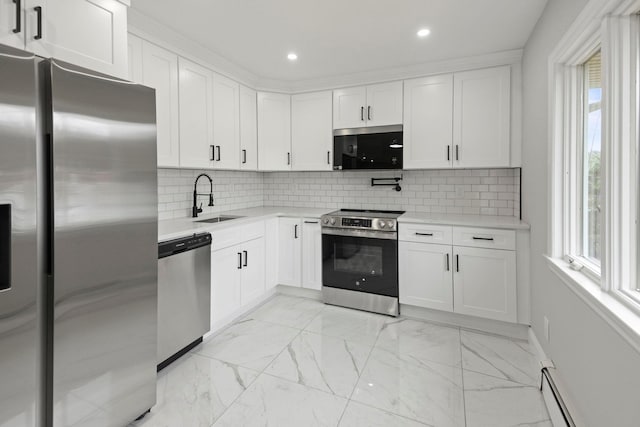161 Cherry St, Northport, NY 11768 - kitchen with appliances with stainless steel finishes, a sink, light countertops, light marble finish floors, and a baseboard heating unit