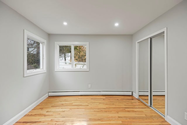 161 Cherry St, Northport, NY 11768 - unfurnished bedroom with recessed lighting, light wood-type flooring, a closet, baseboards, and baseboard heating