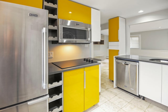 161 Cherry St, Northport, NY 11768 - kitchen with appliances with stainless steel finishes, dark countertops, light tile patterned floors, white cabinetry, and a sink