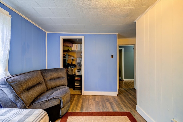 living area featuring wood finished floors, ornamental molding, and baseboards