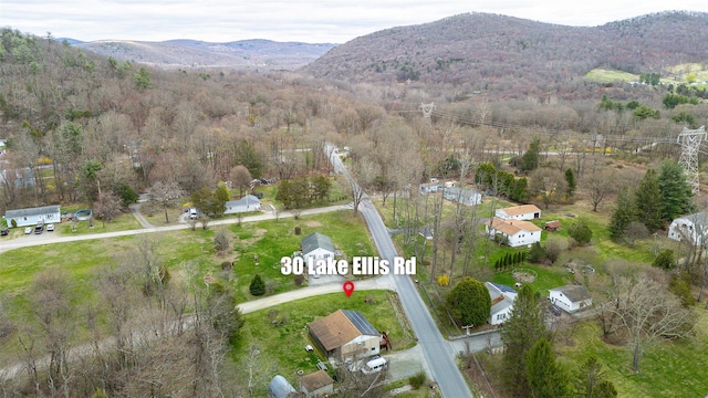 aerial view featuring a wooded view and a mountain view