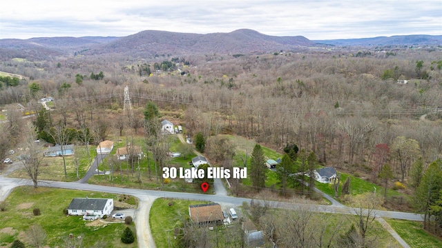 birds eye view of property featuring a wooded view and a mountain view