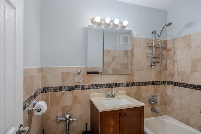 88-25 155th Ave Unit 6L, Howard Beach, NY 11414 - bathroom featuring visible vents, vanity, tile walls, and bathtub / shower combination