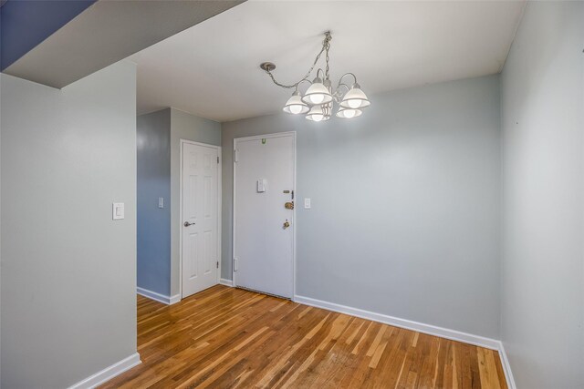 88-25 155th Ave Unit 6L, Howard Beach, NY 11414 - spare room with wood finished floors, baseboards, and a chandelier