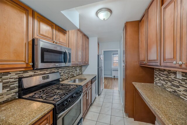88-25 155th Ave Unit 6L, Howard Beach, NY 11414 - kitchen featuring brown cabinetry, appliances with stainless steel finishes, radiator heating unit, and a sink