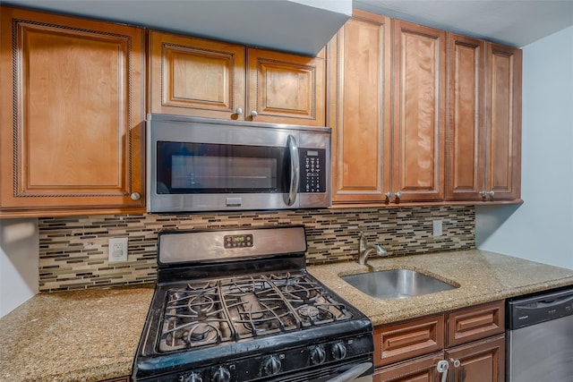 88-25 155th Ave Unit 6L, Howard Beach, NY 11414 - kitchen featuring brown cabinetry, light stone countertops, a sink, stainless steel appliances, and backsplash