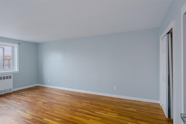 88-25 155th Ave Unit 6L, Howard Beach, NY 11414 - unfurnished bedroom with baseboards, radiator, and light wood finished floors