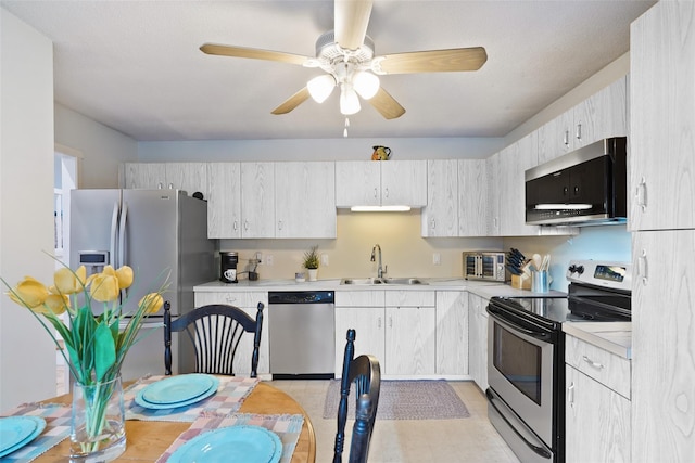 446 Heritage Hls Unit C, Somers, NY 10589 - kitchen featuring appliances with stainless steel finishes, a sink, light countertops, a ceiling fan, and light floors