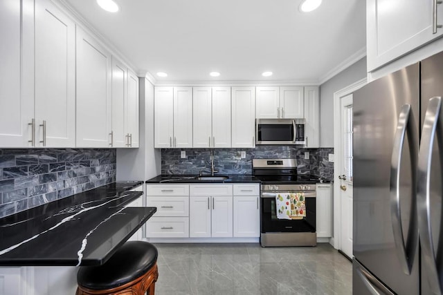 kitchen featuring appliances with stainless steel finishes, white cabinets, ornamental molding, and backsplash