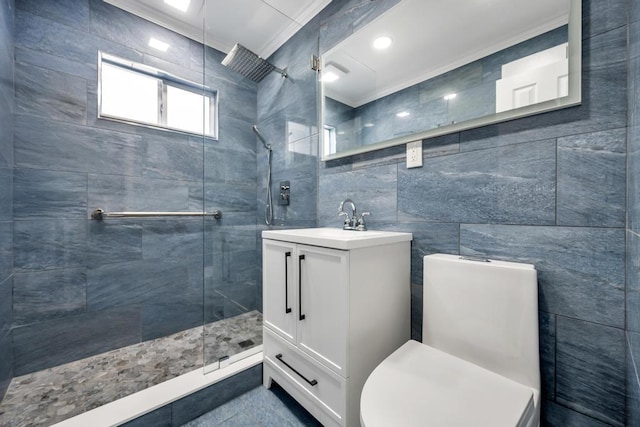 bathroom featuring crown molding, tile walls, vanity, and a tile shower