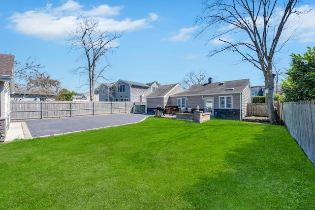 view of yard featuring a patio, a residential view, and a fenced backyard